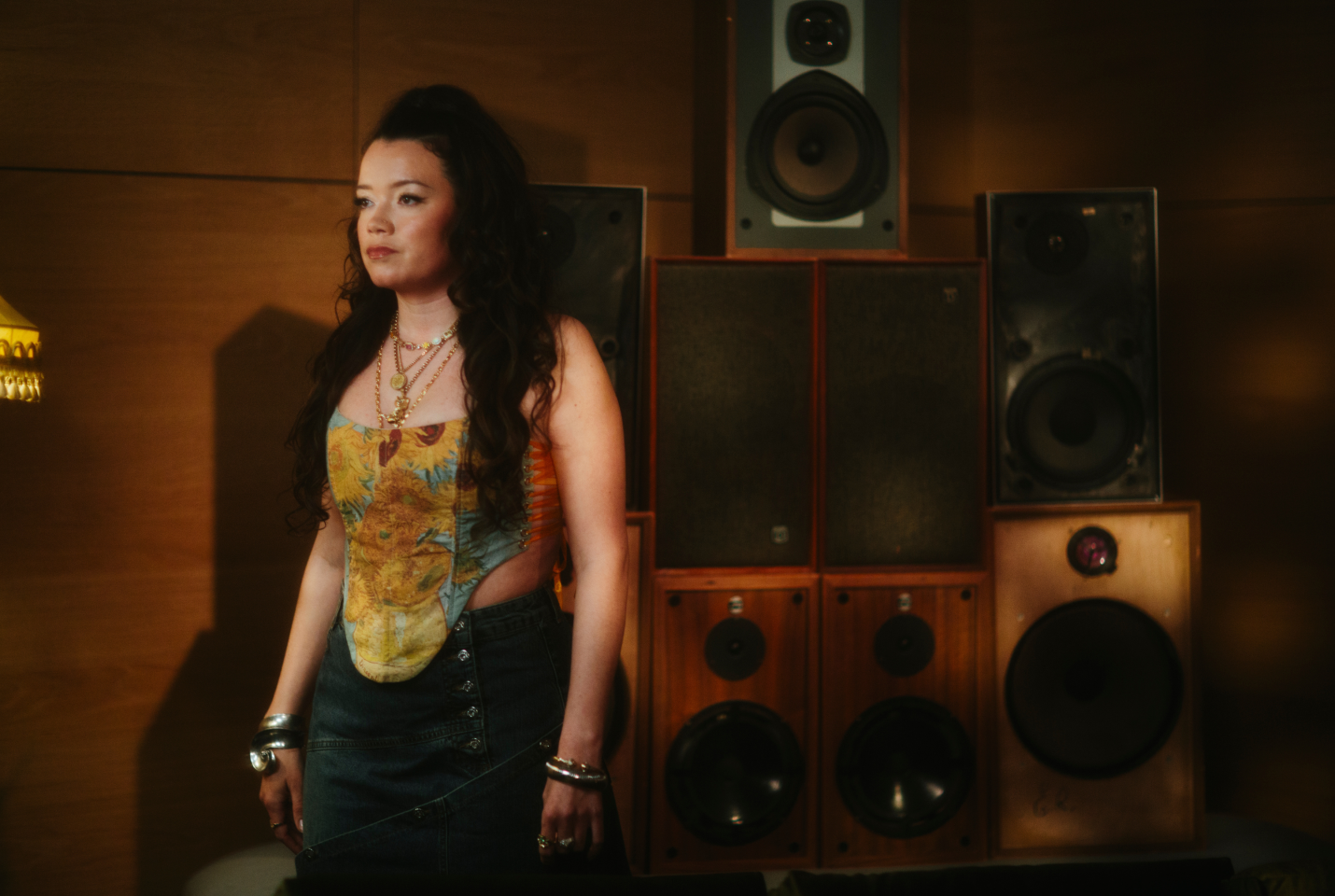 Musician Clementine Douglas standing in front of speakers